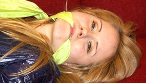 Samantha tied and gagged on a sofa wearing a hot lightblue shiny nylon shorts and a very shiny blue rian jacket (Pics)
