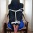 Stella tied and gagged on a chair wearing a blue shiny nylon shorts and a rain jacket (Pics)