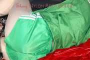 ***HOT HOT HOT*** LUCY tied and gagged on a bed with a bar and a cloth gag wearing sexy green shiny nylon shorts and a green rain jacket (Pics)