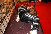 Mara tied with tape and gagged on a princess bed in an old cellar wearing an black sauna suit (Pics)