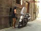 016141 Eve Tries To Hide Beside A Parked Motorcycle As She Pees In The Street