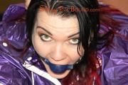 Jill tied and gagged on a table wearing a shiny purple/silver PVC sauna suit (Pics)