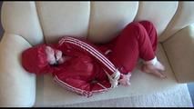 Jill tied, gagged and hooded on a white sofa wearing a sexy shiny red nylon shorts and a red rainjacket (Video)