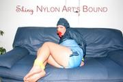 Jill tied, gagged and hooded on a sofa wearing sexy shiny nylon shorts and a rain jacket (Pics)