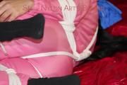 Lucy tied and gagged on a sofa wearing a pink shiny nylon skibib (Pics)