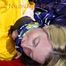 Sonja tied and gagged on bed with cuffs and neckband wearing a sexy blue shiny nylon shorts and a yellow rain jacket (Pics)