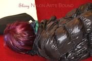 Mara tied and gagged on a sofa wearing a shiny black rain pants and down jacket (Pics) 