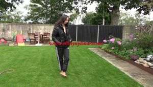 Watching Aiyana wearing a sexy black shiny nylon rainpant and a black shiny nylon down jacket trying the garden shower  (Video)