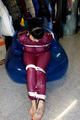 Jill tied and gagged in a semi-transparent purple PVC suit