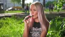 Blonde girl Natalia is vaping on the street