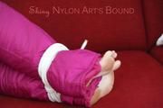 Jill tied and gagged on a red sofa wearing a sexy pink down combination (Pics)