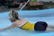 Sexy Sonja wearing a darkblue shiny nylon shorts and a yellow top enjoying the water in the swimming pool (Pics)