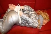 Sophie tied and gagged on the sofa wearing a shiny silver PVC sauna suit (Pics)