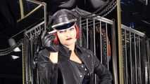 Mistress Tokyo smoking cigarette in leather, gloves and Muir Cap; fetish, POV