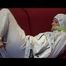 Pia tied and gagged on a sofa wearing a shiny white rainsuit (Video)