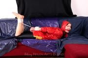 Alina tied and gagged in red nylon shorts and red cagoule
