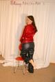 Beautiful archive girl posing on a chair wearing black and red shiny nylon rainwear (Pics)