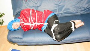 Jill tied, gagged and hooded on the sofa wearing a sexy black shiny nylon pants and two rain jackets (Pics)
