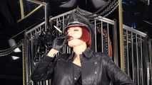 Mistress Tokyo smoking cigarette in leather, gloves and Muir Cap; fetish, POV