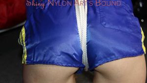 Watching sexy Sonja wearing a sexy shiny nylon shorts in blue and a blue rain jacket being tied and gagged on a stool with ropes and a clothgag (Pics)