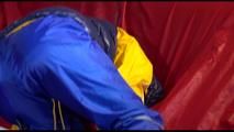 Sonja ties, gagges and hoodes herself on a sofa with a bar and a ball gag wearing a sexy blue shiny nylon rain pants and a yellow rain acket and a blue down jacket (Video)