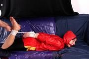 Alina tied and gagged in red nylon shorts and red cagoule