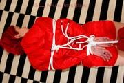 Marlin tied and gagged in red nylon shorts and red cagoule