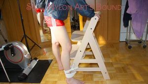 Sonja tied and gagged standing on a chair wearing a sexy red shiny nylon shorts and a darkblue rain jacket (Pics)