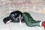 Jill tied, gagged and hooded on a cellar floor wearing a shiny green rain pants and a shiny black down jacket (Pics)