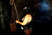 Slave in latex and chains in the horror tower