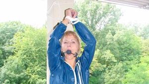 Leonie tied and gagged on a pillar wearing a shiny nylon shorts and a rain jacket (Pics)