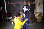 Sandra tied by Stella both wearing shiny nylon rainwear