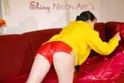 Lucy wearing a sexy red shiny nylon shorts and a yellow rain jacket preparing the sofa to lay down (Pics)