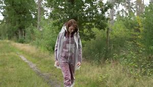 Miss Petra takes a walk in an AGU rain suit, transparent rainsuit and rubber boots (looped version)