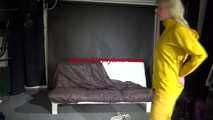 Watching Pia preparing her sofa with a shiny nylon cloth wearing a yellow shiny nylon rainsuit enjoying herslef on the sofa (Video)