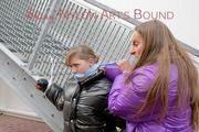 One archive girl tied and gagged by another archive girl outdoor wearing shiny down jackets (Pics)