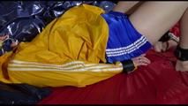 Sonja tied and gagged with a bar and cuffs in bed wearing a very small, hot blue shiny nylon shorts and a yellow rain jacket (Video)