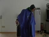 Katharina tied, gagged and hooded on a chair wearing shiny nylon rainwear and over it an rain cape (Video)