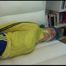 Mara tied and gagged on a white sofa in a reading lounge wearing a sexy blue/yellow shorts and a yellow rain jacket (Video)