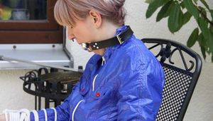 Sexy Mara being tied and gagged on a chair outdoor wearing a sexy shiny nylon shorts and a rain jacket (Pics)