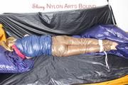 Samantha tied and gagged on bed wearing a brown shiny nylon downpanst and a blue downjacket (Pics)