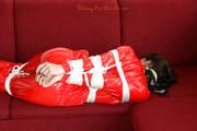 Julia tied and gagged on the sofa in a shiny red PVC Sauna suit (Pics)