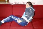 Lucy wearing a blue shiny nylon pants and an oldschool blue rain jacket tied and gagged with ropes on a sofa (Pics)