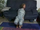 Katharina tied and gagged on a sofa wearing a shiny grey nylon catsuit (Video)