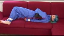 Mara tied and gagged on a sofa wearing sexy shiny rainwear in blue (Video)