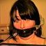 22 YEAR OLD FEISTY DEREK IS MUMMY WRAPPED WITH CLEAR PLASTIC, ELECTRICAL TAPE BOUND & WRAP GAGGED, MOUTH STUFFED & BLACK LEATHER GLOVE HANDGAGGED (D66-10)