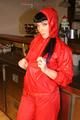 Jill posing in a bar wearing a sexy red rainwear combination with nothing under it (Pics)