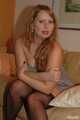 Chubby redhead Benita stripping out of her grey dress and stockings on couch