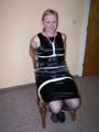 Im schönen neuen schwarzen Kleid an den Stuhl gefesselt