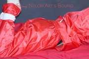 Destiny wearing a sexy red rain suit tied and gagged and hooded with ropes and a cloth gag on a bed (Pics)